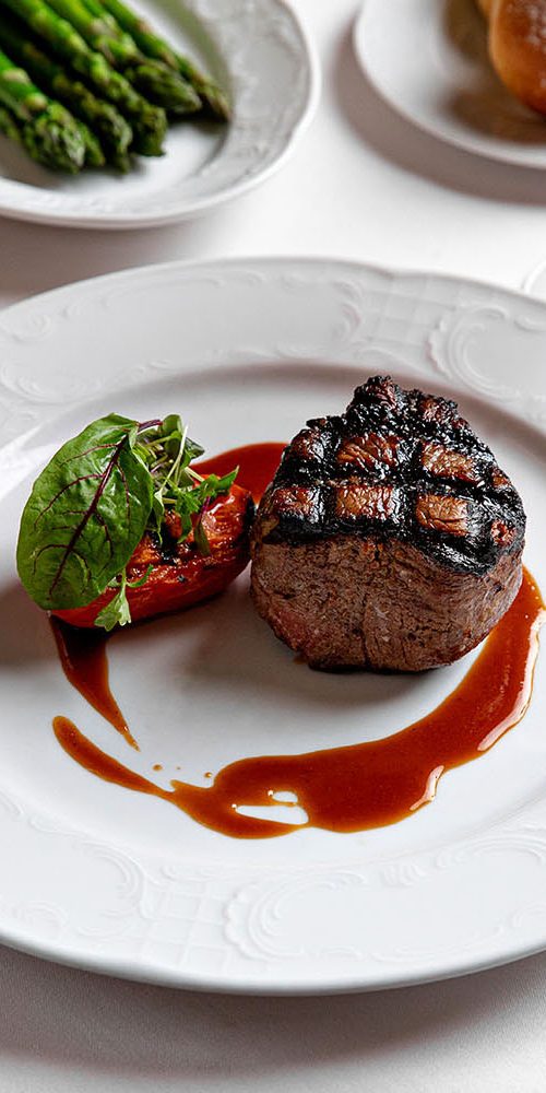 A dining plate with steak and sides